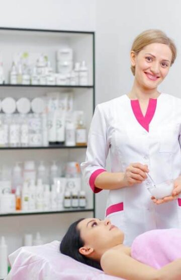 Young woman beautician is doing the cleaning procedure in the beauty salon. Face Skin Care. Cleansing Procedure. Cosmetology.